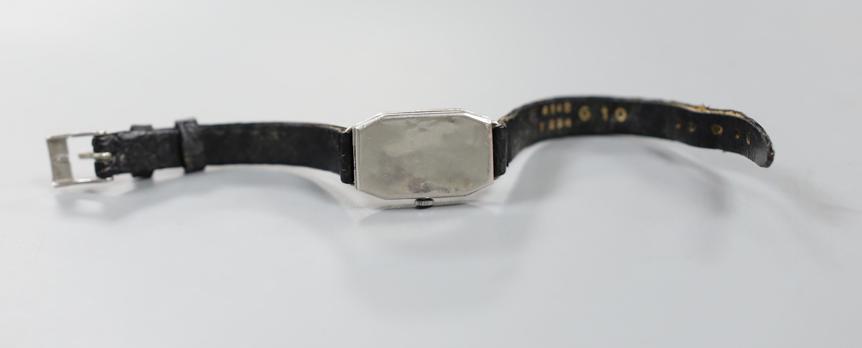 A lady's white metal (stamped platinum) and diamond set cocktail watch, on a leather strap, cased diameter 18mm, gross weight 15.8 grams.